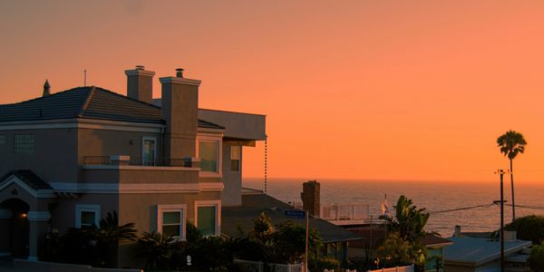 Sunset view over coastal houses by the ocean.