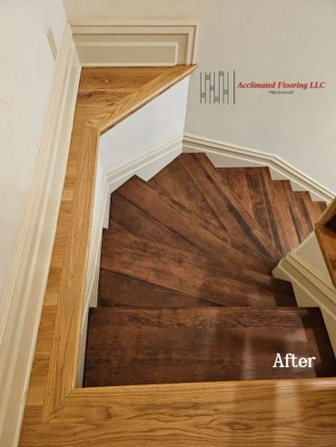 Newly refinished dark hardwood stairs with light wood trim.