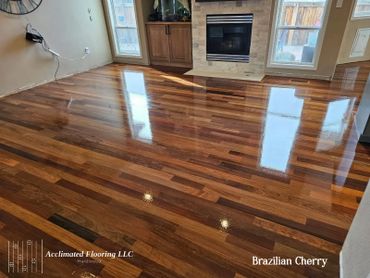 Shiny Brazilian cherry hardwood flooring in a living room with fireplace.