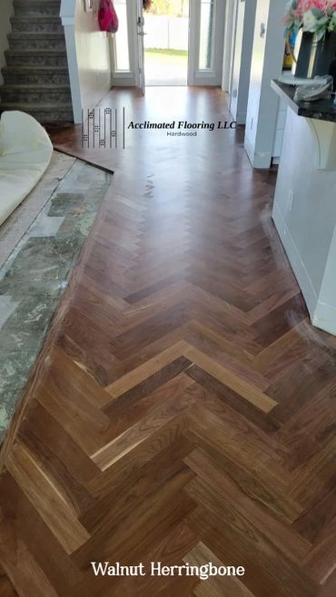 Elegant walnut herringbone hardwood flooring in a modern home entryway.
