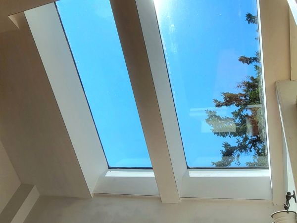 View of clear blue sky through two rectangular skylights.