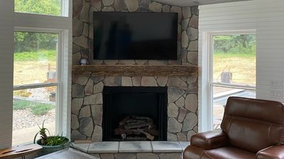 Professional TV mounting above stone fireplace by Home AV Specialist.