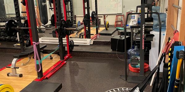 Power rack with resistance bands, lifting platform and free weights at TIS Fitness Systems strength