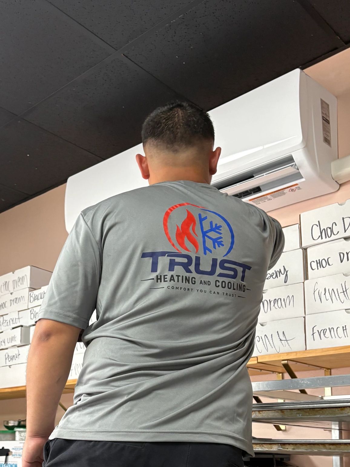 Technician adjusting air conditioning unit.
