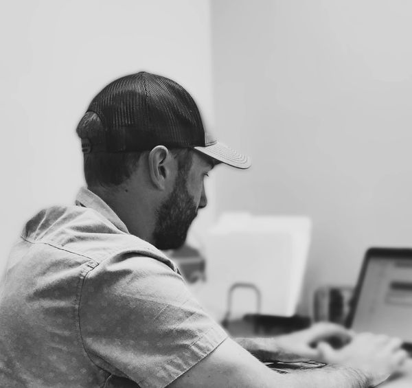 Branding photo in action while man is working on a laptop in his office.