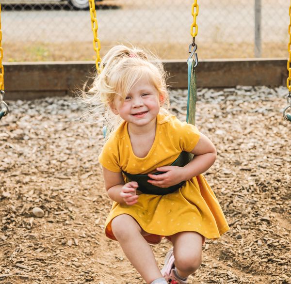 Branding photo of a young girl on a swing.