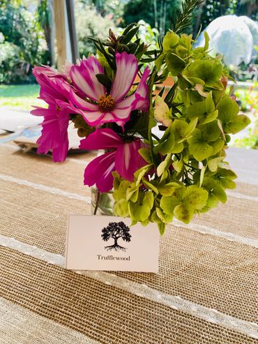 A bouquet of flowers on the table with our trufflewood business card