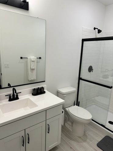 Modern bathroom with black fixtures and white decor.