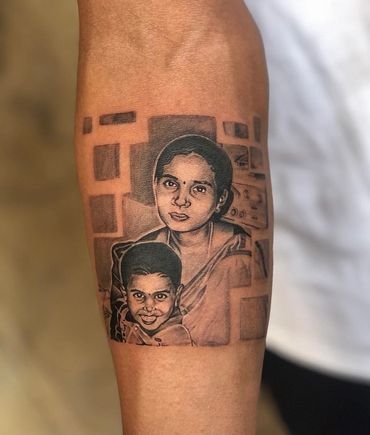 Realistic tattoo of a woman and a child on a forearm with geometric background.