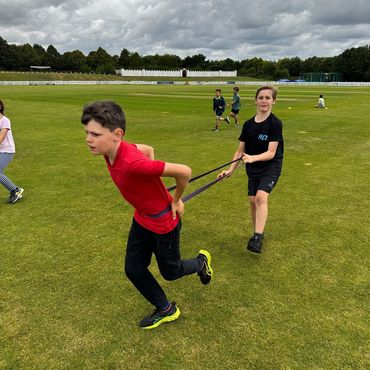 a child using a resistance band whilst running to add resistance.