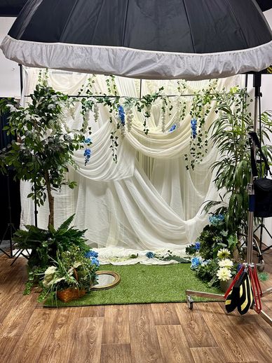 Custom garden set with white draping and floral installations — built in-house at Studio RED, RedHed