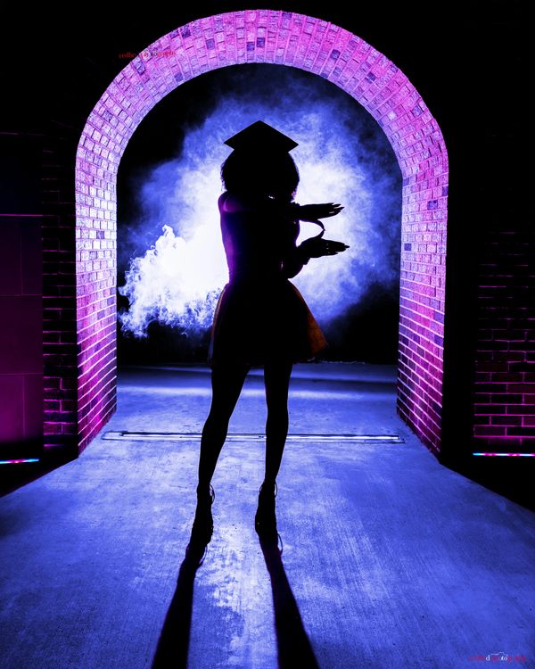 Dramatic silhouette grad portrait in purple-lit brick archway smoke effect editorial luxury grad pho