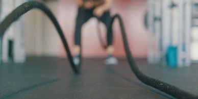 someone using battle ropes in a gym