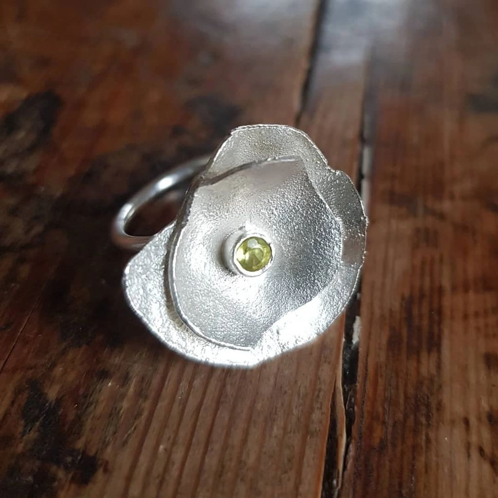 Reticulated silver abstract modern flower ring with an acid yellow sapphire detail.