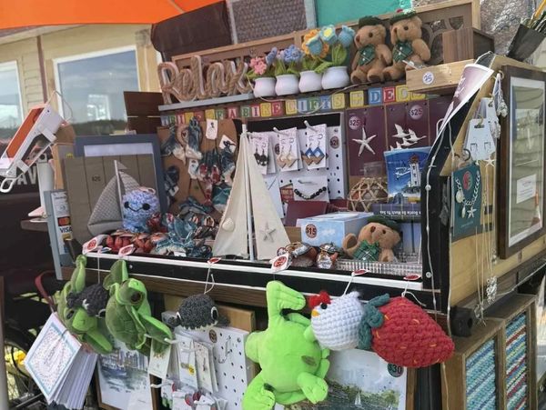 A colorful outdoor market stall with handmade crafts and plush toys.