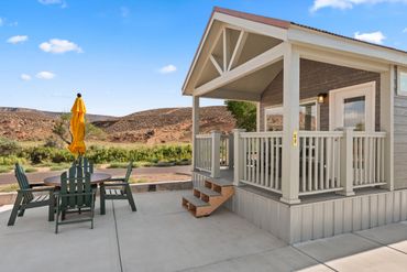 Cozy porch with outdoor dining set and desert landscape view.