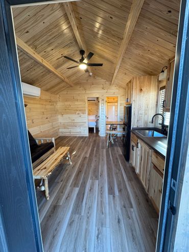 Cozy wooden cabin interior with modern amenities and rustic furniture.