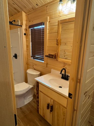 Cozy wooden cabin bathroom with modern fixtures and a shower.
