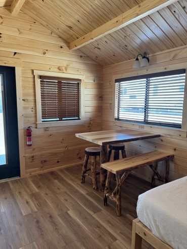 Cozy wooden cabin interior with rustic furniture and natural light.