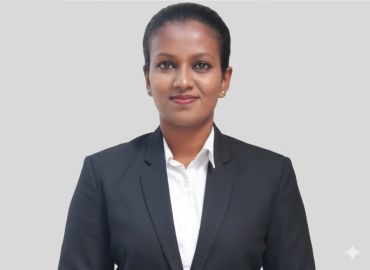 Professional woman in a black blazer and white shirt posing confidently.