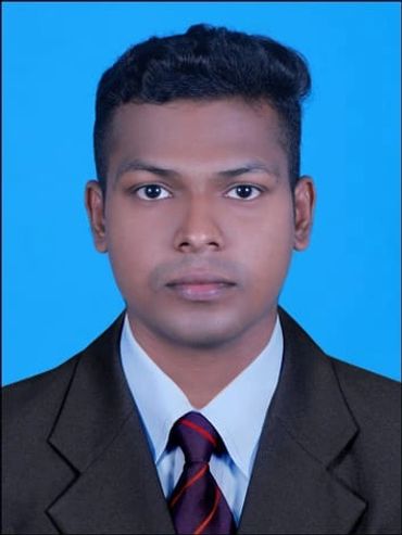 Professional headshot of a young man in a suit with a blue background.