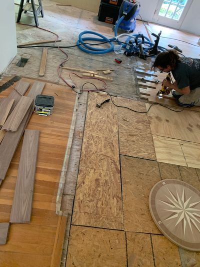 Person installing wooden flooring.