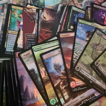 A scattered pile of Magic: The Gathering cards with diverse artwork and card types.