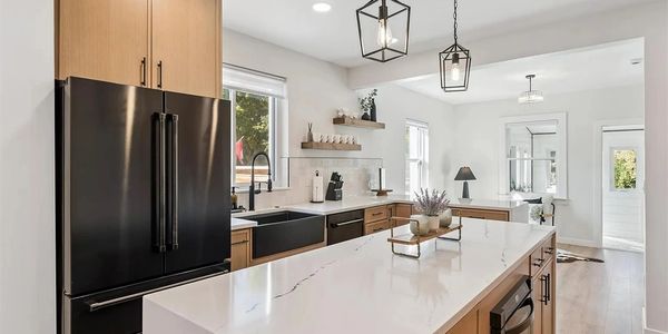 Modern kitchen with black appliances and wooden cabinetry.