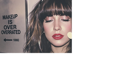 Woman with bold makeup and a sign saying makeup is overrated.