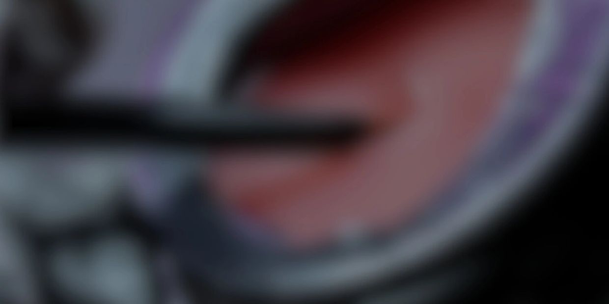 Blurred image of a red and gray object with a black rod.