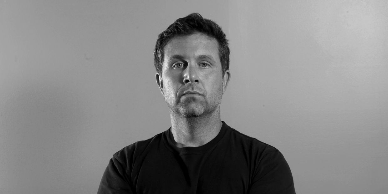 Serious man with folded arms in black and white.