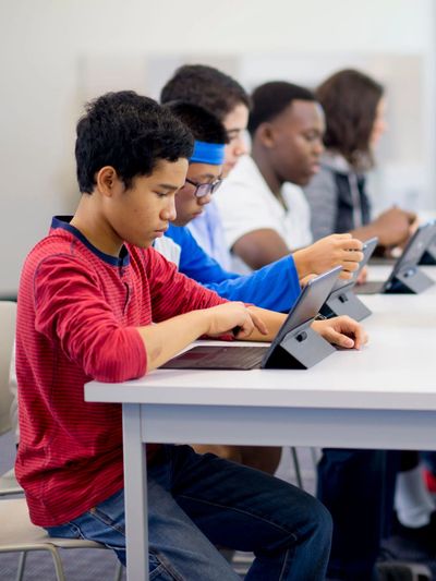 Middle school students using tablets during a classroom technology lesson.