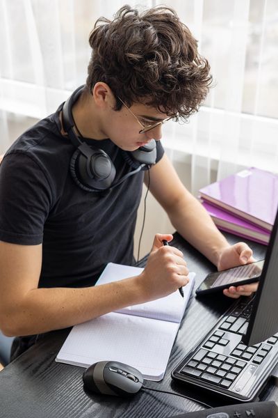 Teenager studying at home on a computer.