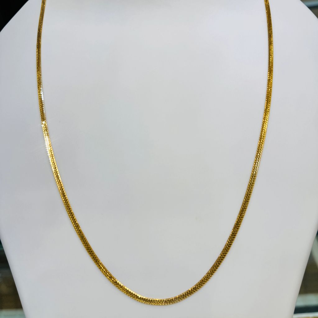 Elegant thin gold chain displayed on a white bust.