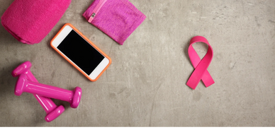 Breast cancer awareness fitness gear with pink dumbbells, towel, and ribbon.