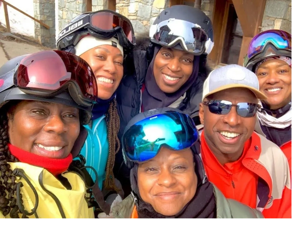 A group of six friends smiling in ski gear, ready for adventure.