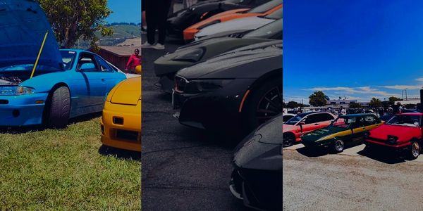 A blue car with its hood open beside a yellow car on grass.
