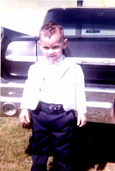 Jim in 1964 standing beside the family car, a Pontiac, at their farm in Clyattville, Georgia.