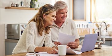 Retirement, investment and couple on laptop and paperwork for online