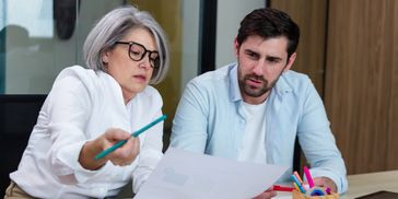 Businesswoman explaining a document to a businessman in a coworking space
