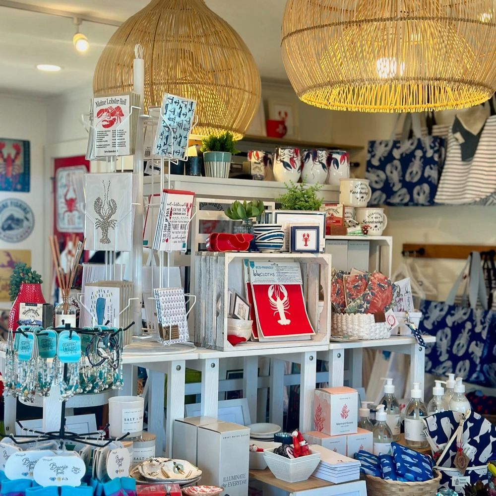 Cozy shop display featuring lobster-themed decor and coastal gifts under woven pendant lights.