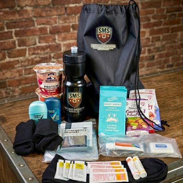Emergency preparedness kit with water bottle, snacks, toiletries, and first aid items.