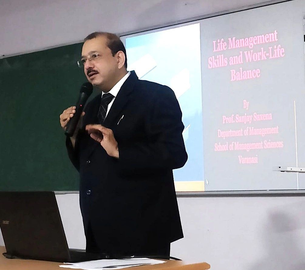 Stack of books next to pencils in a holder and a camera.