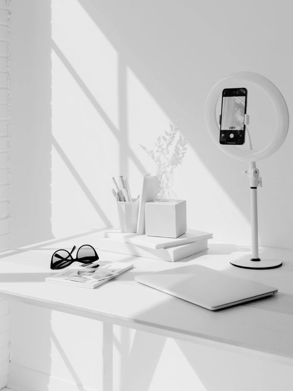 Social media strategies featuring phone and ring light on desk.