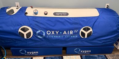 Blue Oxy Air 32 hyperbaric chamber with control gauges and Oxygen Health Systems branding.