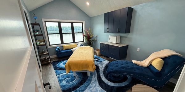 Serene spa room with blue accents and a lake view.