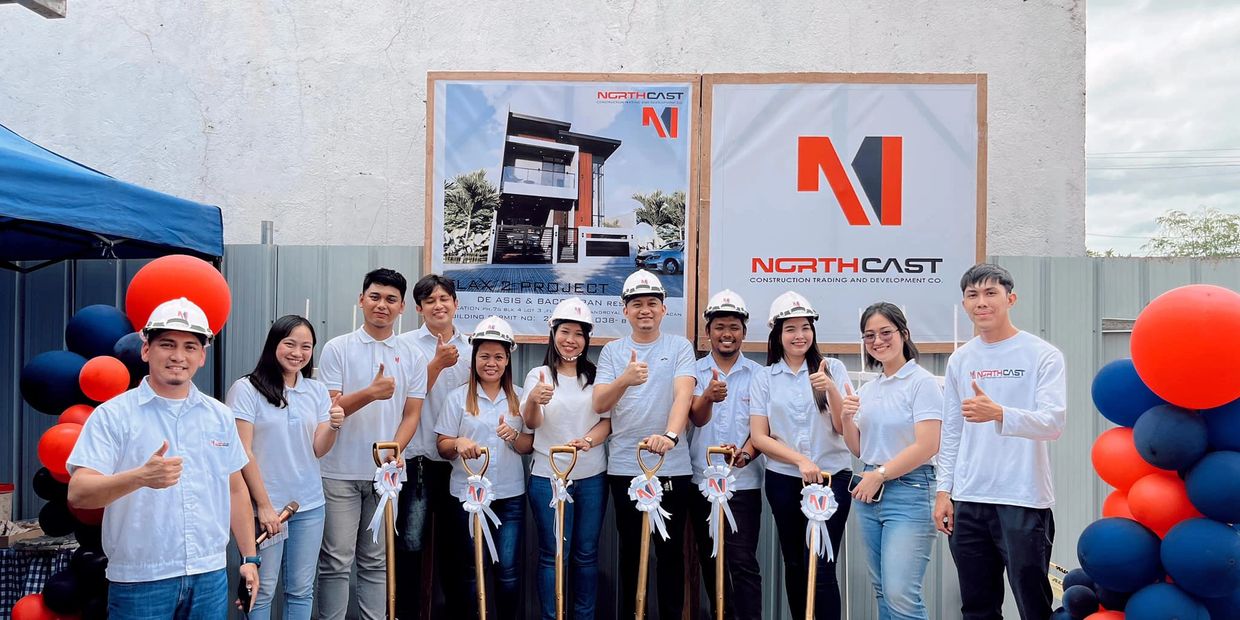 Group of construction team members giving thumbs up at groundbreaking ceremony with golden shovels.