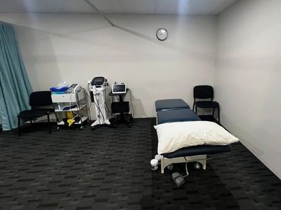Medical examination room with treatment table and equipment.