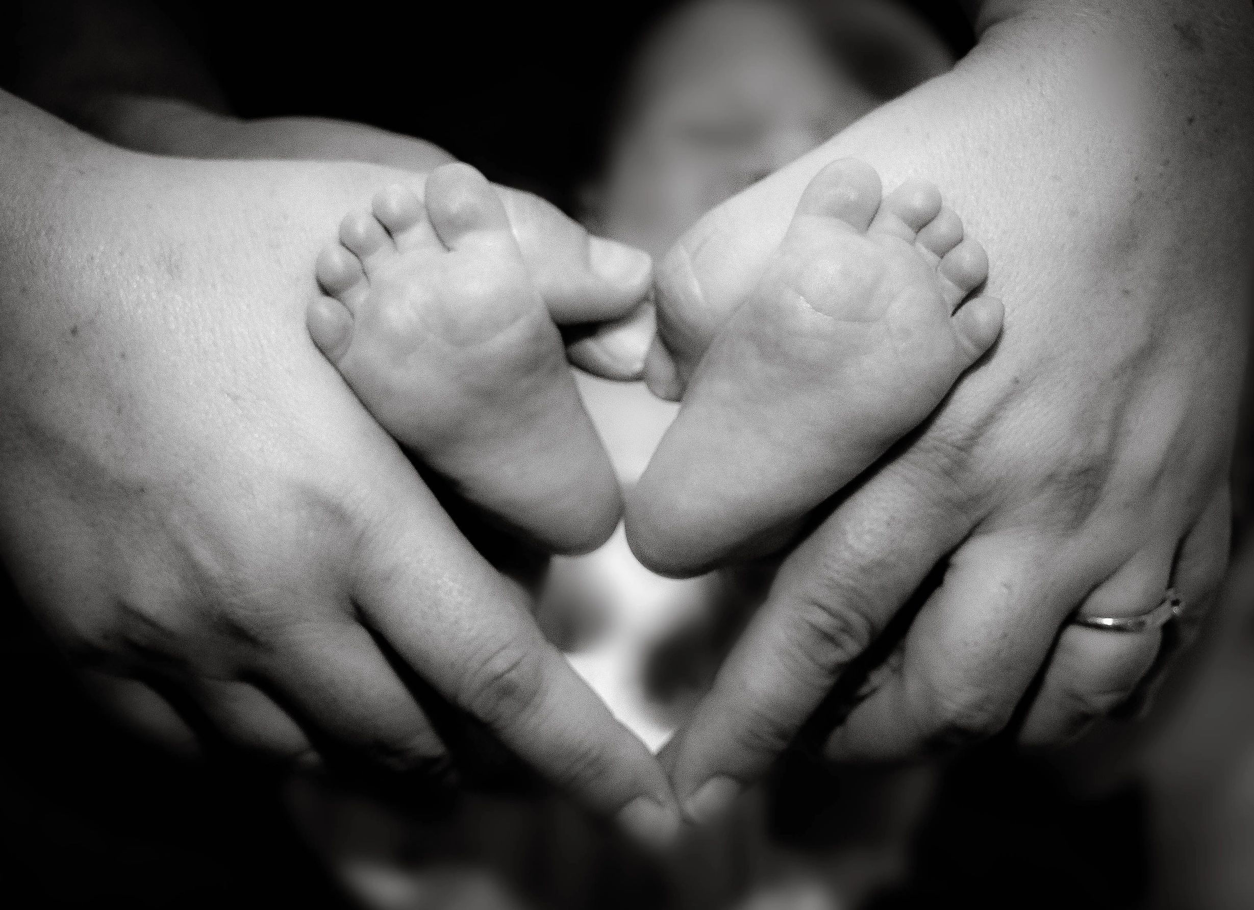 mom and dad's hands on baby's feet