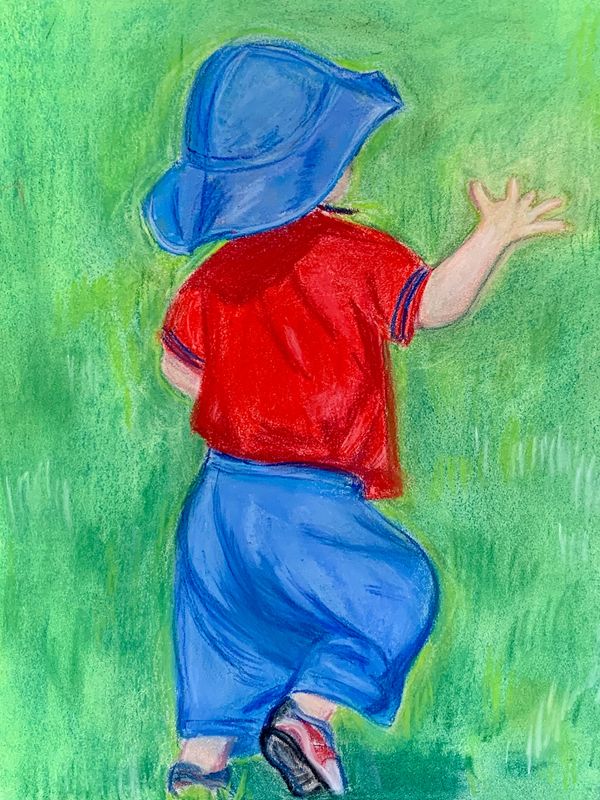 Toddler running away from viewer on grass in park.
